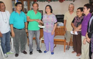 Calabanga Mayor Eduardo Severo receives the P1M check from Director Honorita Bayudan